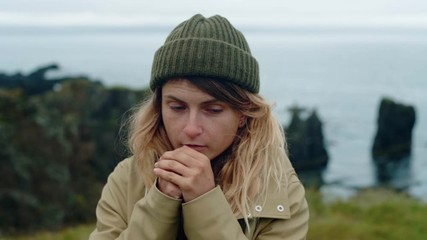 Young woman warms hands with breath in norway