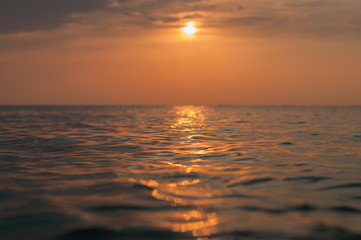 A beautiful sunset on the sea in the summer with a tender pink and orange and lilac color