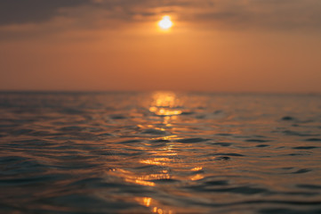 A beautiful sunset on the sea in the summer with a tender pink and orange and lilac color