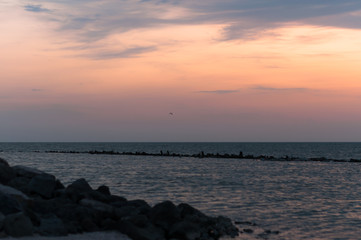 A beautiful sunset on the sea in the summer with a tender pink and orange and lilac color