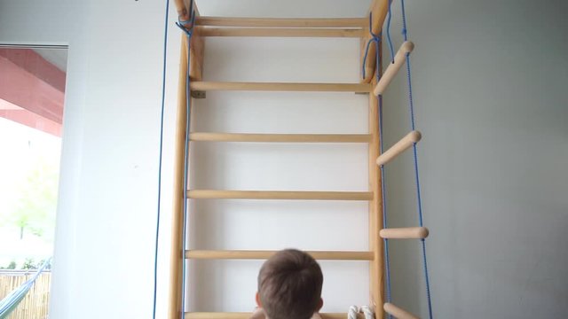 a boy climbs the swedish stairs in the children's gym