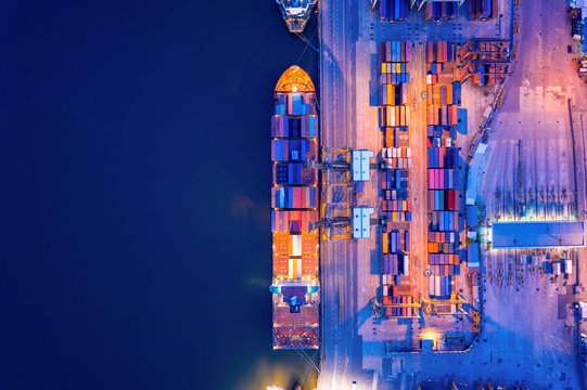 Aerial view of business port with shore crane loading container in container ship in import/export and business logistics with crane and shipping port cargo.International transportation concept.