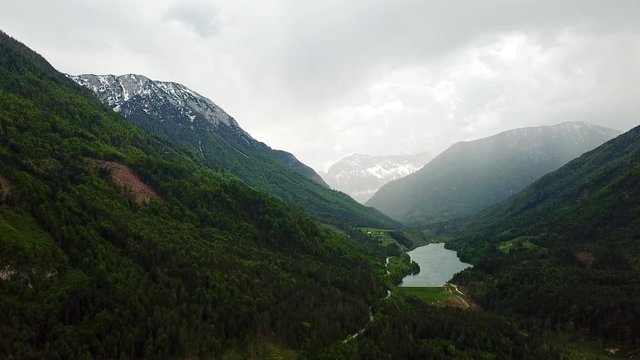 Drone Footage of Freibach Stausee Lake at the Base of Dark Green Pine Tree Forest Valley near Gallizien Austria, Europe with a Cloudy and Misty Sky