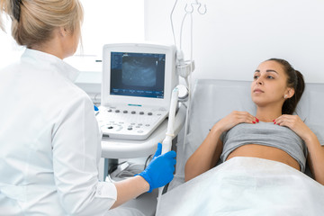 The gynecologist sets up the ultrasound machine and explains to the patient how the study will be...
