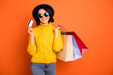 Photo of wealthy trendy cheerful nice girl having found discounts and sales at shopping mall and bought lots of packages while isolated with orange background