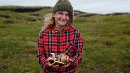 Young woman holds wild mushrooms in hands