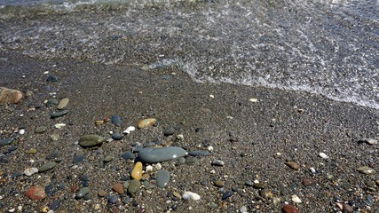 Arena rocosa y orilla de una playa de arena oscura