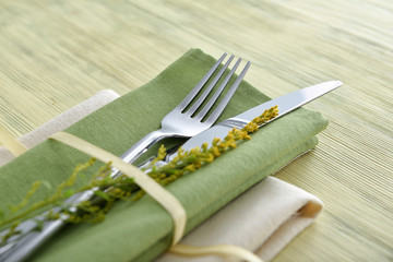 Clean cutlery with napkins on wooden background, closeup