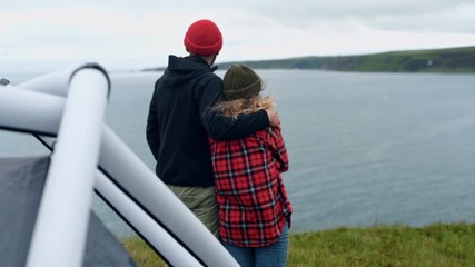 Young couple enjoys sunset at epic camping spot