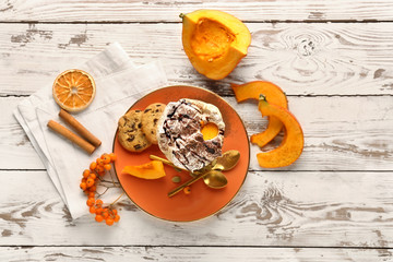 Glass of tasty pumpkin coffee on white table