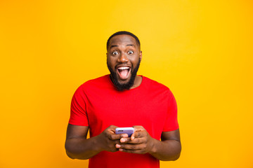 Photo of funny casual delighted nice black man friendly seeing good news on his phone while...