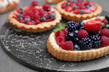 Sweet tartlets with berries on board, closeup