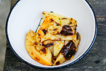 Veggy Succulent grilled vegetables with assorted sweet peppers, garnished with herbs served in a dish with ingredients visible behind