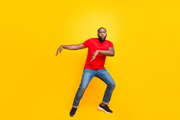 Fototapeta na wymiar Full length body size photo of black man dancing with face serious while isolated with yellow background
