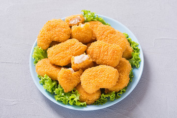 Chicken nuggets in plate on rustic background