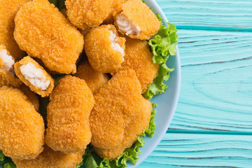 Chicken nuggets in plate on rustic background