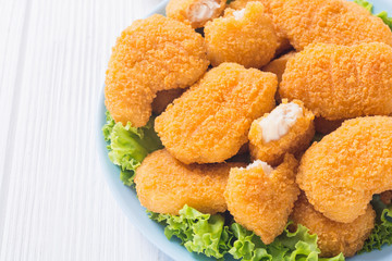 Chicken nuggets in plate on rustic background