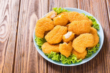 Chicken nuggets in plate on rustic background