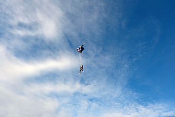 Fototapeta premium Skydiving. Blonde girl is flying in the blue sky.
