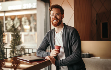 Bearded cheerful freelancer in cafe