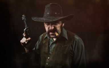 A gritty cowboy with a mean looking face holding a revolver handgun.