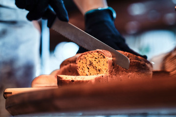 Process of seeded loaf slicing at the kitchen for breakfast at posh hotel by baker.