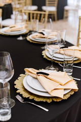 Modern design of a festive banquet in the restaurant with golden details and luxury dishes.