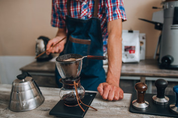 Young barista mixed filter coffe with spoon