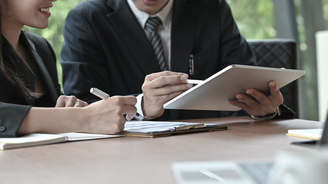 Business people consulting with tablet and finance paper.