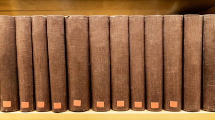 Antique leather cover books on wooden bookshelf in university public library. Reading philosophy or history studying. Education research and self learning concepts