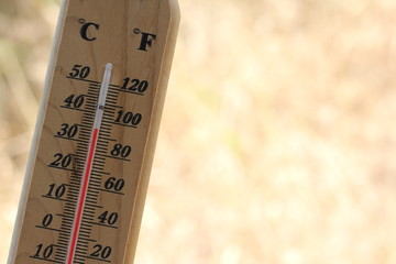 A hot day on the summer,Thermometer  temperature is 35 degrees Celsius with blur dry grass background 