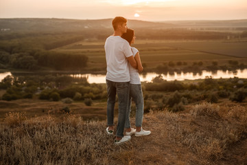 Adult couple admiring sunset in nature
