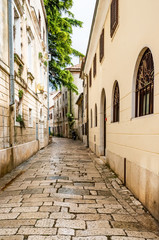 A typical narrow European street with a cobbled pavement. Croatia, the city of Porec