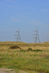 Electricity pylon towers on a misty morning in Kent, UK.
