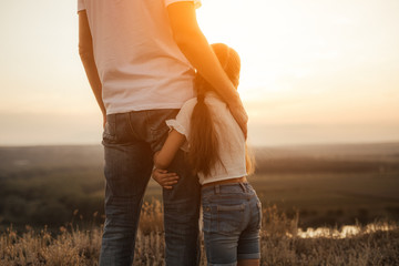 Happy father and daughter hugging while standing at countryside