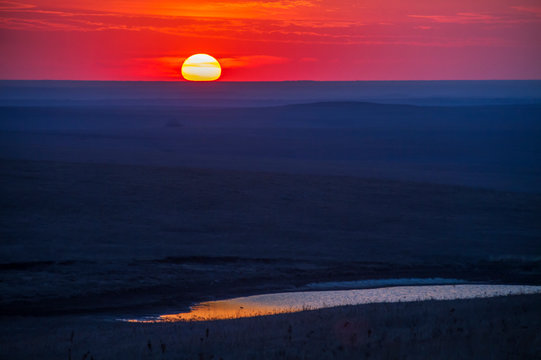 sunset over the Flint Hills of Kansas; small pond reflection