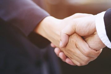 Closeup of a businessman hand shake businesswoman between two colleagues  OK, succeed in business Holding hands. Leave space for writing descriptive text