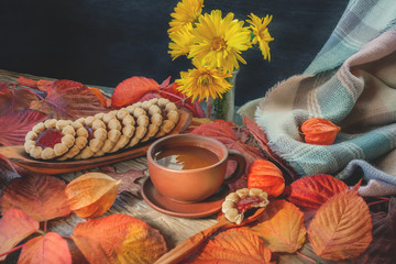 beautiful autumn composition with tea. autumn leaves and a Cup of homemade cookies on a rustic tree background. the concept of the fall season. soft selective focus