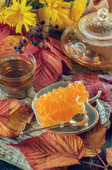 beautiful autumn composition with tea. autumn leaves and a Cup with a clear teapot and grape sugar on a rustic tree background. the concept of the fall season. soft selective focus
