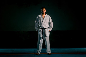 The karate guy in white kimono and black belt training karate