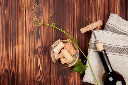 Glass bottle of wine with corks on wooden table background - Image