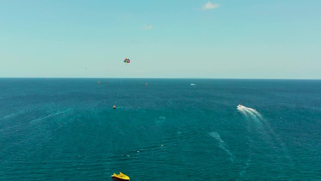 Tourists on a parachute over the sea, aerial view. Tourists parasailing on the Boracay, Philippines.
