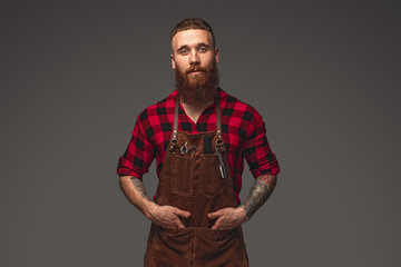 Confident stylist in brown apron