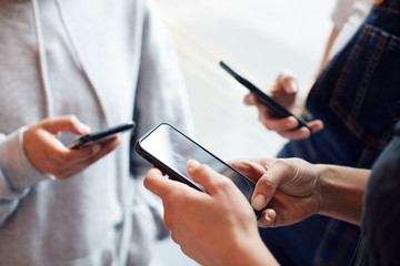 Close Up Of Businesswomen Using Mobile Phones In Modern Office