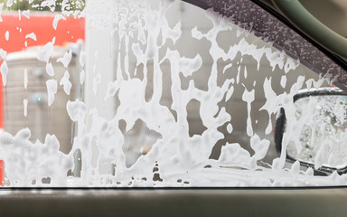 Car washing in a self-service car wash station, Bubble soap, Shooting from inside the car.