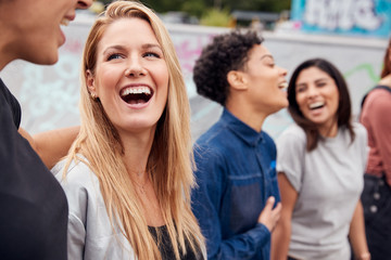Obraz premium Group Of Female Friends Posing For Selfie On Mobile Phone In Urban Skate Park