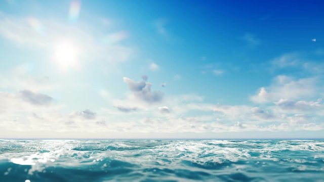 Ocean view. Beautiful seascape with sun shining in the left upper corner of the scene with some clouds floating in the blue sky at the horizon line. There are moderate waves on water surface.