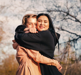 Multiethnic friendship and support concept, two young women a european and an asian sincerely...
