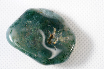 Moss Agate is a type of chalcedony that contains minerals of green color in the stone, formed in filaments and other structures of moss.  - obrazy, fototapety, plakaty