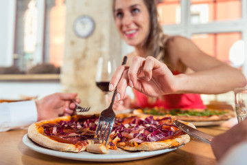 Obraz na płótnie Canvas Woman eating pizza from her boyfriend's plate